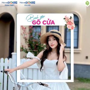 a woman in a white dress and a hat and a bike at Novaworld Phan Thiết - Luxury villa 3 Phòng Ngủ in Phan Thiet