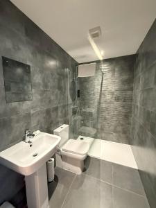 a bathroom with a sink and a toilet and a shower at Coastal Plaza in Blackpool +93 photos