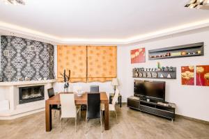 Un comedor con una mesa y un televisor. en Mary's modern apartment, en Kissamos