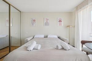 una camera bianca con un grande letto con cuscini bianchi di Cozy Cannes a Cannes