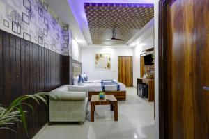 a bedroom with a bed and a couch and a table at Hotel The RTS Plaza in New Delhi