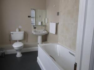 een badkamer met een toilet, een bad en een wastafel bij The Duke of Wellington Wetherspoon in Minehead