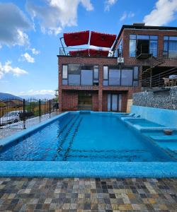 a large swimming pool in front of a building at Panorama Lux Guest House in Chimgan