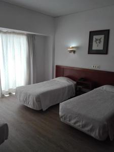 Postel nebo postele na pokoji v ubytování Residencial Greco