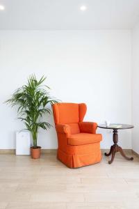 an orange chair in a room with a table and a plant at Las Ranas 1 in El Durazno