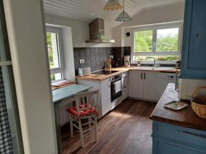 a kitchen with white appliances and two windows at O'TY'ZOISEAUX - Plus proche de la nature - Meublé tourisme classé 4 étoiles in Scaër