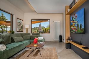 een woonkamer met een groene bank en een tafel bij VILLA PROVENZA 12&4, Emma Villas in Cefalù