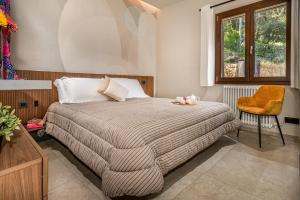 een slaapkamer met een bed, een stoel en een raam bij VILLA PROVENZA 12&4, Emma Villas in Cefalù +37 foto's