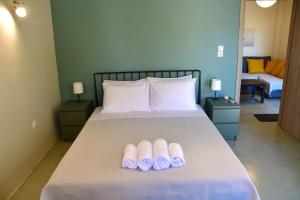 een slaapkamer met een bed met twee slippers erop bij Olive tree house in Aegina Town