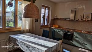 a kitchen with a table in the middle of it at Anna's Cosy Apartment in Illmitz