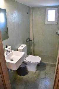een badkamer met een wit toilet en een wastafel bij Olive tree house in Aegina Town