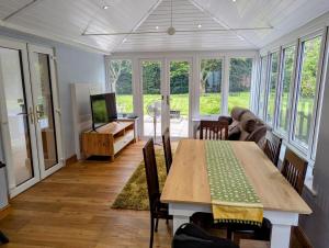una sala de estar con una mesa y un sofá en 4 Bed 4 Bathroom Home, en Muxton