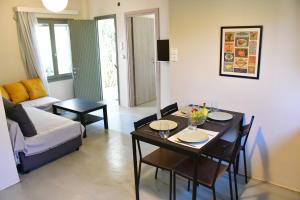 een woonkamer met een tafel en een bank bij Olive tree house in Aegina Town +23 foto's