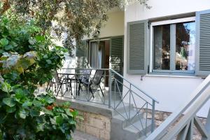 een huis met een balkon met stoelen en een tafel bij Olive tree house in Aegina Town