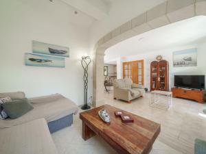 ein Wohnzimmer mit Sofa und Tisch in der Unterkunft Holiday Home Sunwing Beach by Interhome in Port d'Alcúdia