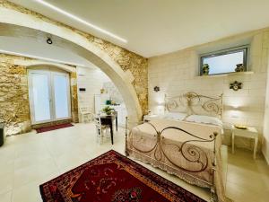 a bedroom with a bed and a table and a window at Riviera del Mare House in Siracusa