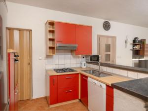 a kitchen with red cabinets and a stove top oven at Holiday Home Angels Retreat by Interhome in Maslenica +50 photos