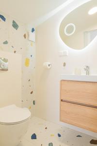 a bathroom with a toilet and a rock wall at BOSMAN Karwia - Pokoje 100m od Plaży in Karwia +25 photos