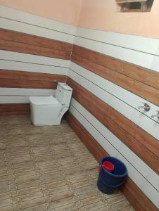 a bathroom with a toilet and a bucket at Omji - Sant Manas Bhushan Ashram Yamunotri, 200m from Helipad in Kharsālī