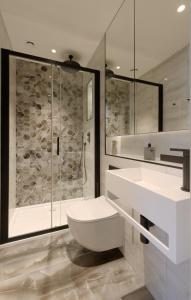 Un baño con ducha, inodoro y lavabo. en South Kensington Studios by D'Montrio, en Londres
