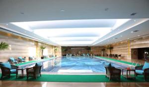 a large swimming pool in a hotel room at JinJiang International Hotel Urumqi in Ürümqi