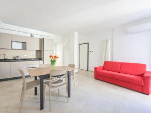 een woonkamer met een rode bank en een tafel bij Apartment Pianosa I by Interhome in Follonica
