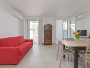 een woonkamer met een rode bank en een tafel bij Apartment Pianosa I by Interhome in Follonica +20 foto's