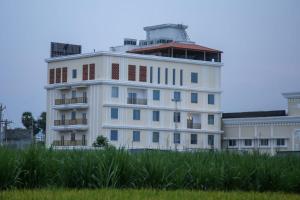 蒂鲁瓦纳马莱Leaf Hotel的田野中间的白色建筑