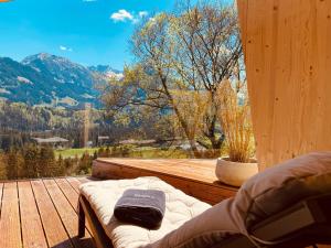 a bed on a wooden deck with a view of a mountain at Hotel Bergflair in Fischen