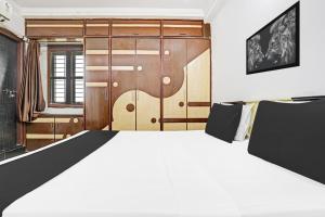 a bedroom with a large white bed and wooden cabinets at Super Hotel O J3 LUXURY ROOMS in Guntūr