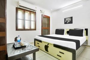 a bedroom with a large bed and a table at Super Hotel O J3 LUXURY ROOMS in Guntūr