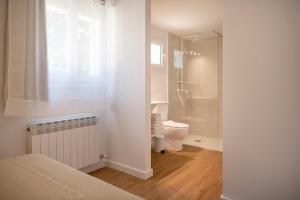 a white bathroom with a toilet and a shower at La Caseta in Sant Jaume de Llierca +19 photos
