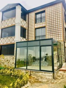 a glass house in front of a building at Şahin Konağı in Degirmen