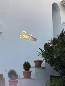 a sign on the side of a building with potted plants at Sienalice Naxos Next to The Beach in Naxos Chora