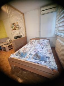 a bedroom with a bed with two pillows on it at Apartman Wish in Belgrade