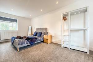 een slaapkamer met een bed en een boekenplank bij Central Warwick townhouse within easy reach of Stratford upon Avon and Cotswolds in Warwick