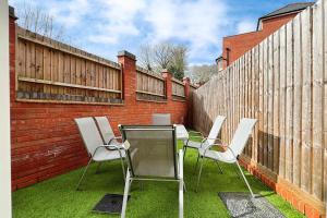 een terras met een tafel, stoelen en een hek bij Central Warwick townhouse within easy reach of Stratford upon Avon and Cotswolds in Warwick