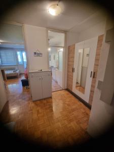 a living room with a hallway with a door and wooden floors at Apartman Wish in Belgrade +6 photos