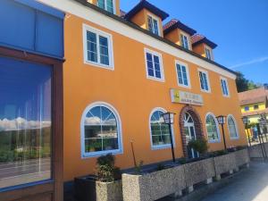 an orange building with white windows on a street at Asia wok gasthof in Ybbs an der Donau