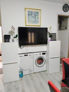 sala de estar con lavadora y TV en Bet El Cozy & Comfy Room 4, en Parkside 6 fotos más
