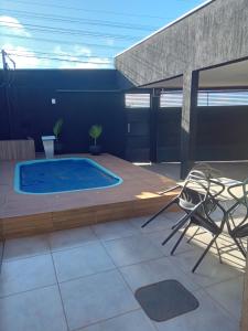 a patio with a swimming pool and two chairs at Casa de alto padrão in Macacos