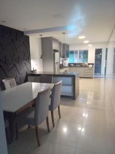a kitchen and dining room with a table and chairs at Casa de alto padrão in Macacos