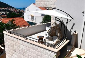 a balcony with an umbrella and a basket at Dubrovnik Icy Guest House in Dubrovnik