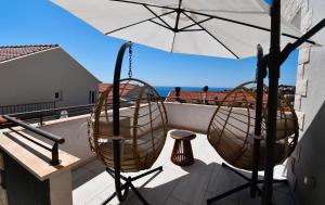 a balcony with two chairs and an umbrella at Dubrovnik Icy Guest House in Dubrovnik