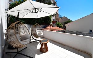 a balcony with two chairs and an umbrella at Dubrovnik Icy Guest House in Dubrovnik