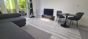 a living room with a couch and a table and a tv at Treetops Studio Apartment in Penn
