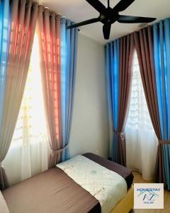 a bedroom with curtains and a bed with a fan at Homestay AZ Kulim in Kulim