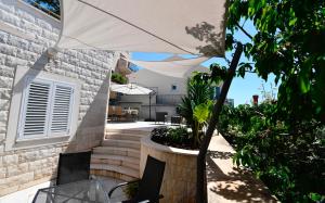 a patio with an umbrella and a table and chairs at Dubrovnik Icy Guest House in Dubrovnik