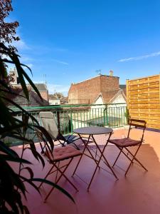 two chairs and a table on a patio at "Nuits du désert" - Appartement avec terrasse in Saint-Quentin