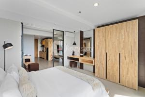 Un dormitorio con una cama blanca y un escritorio. en Sariha by Kozystay - Nusa Dua, en Nusa Dua 18 fotos más